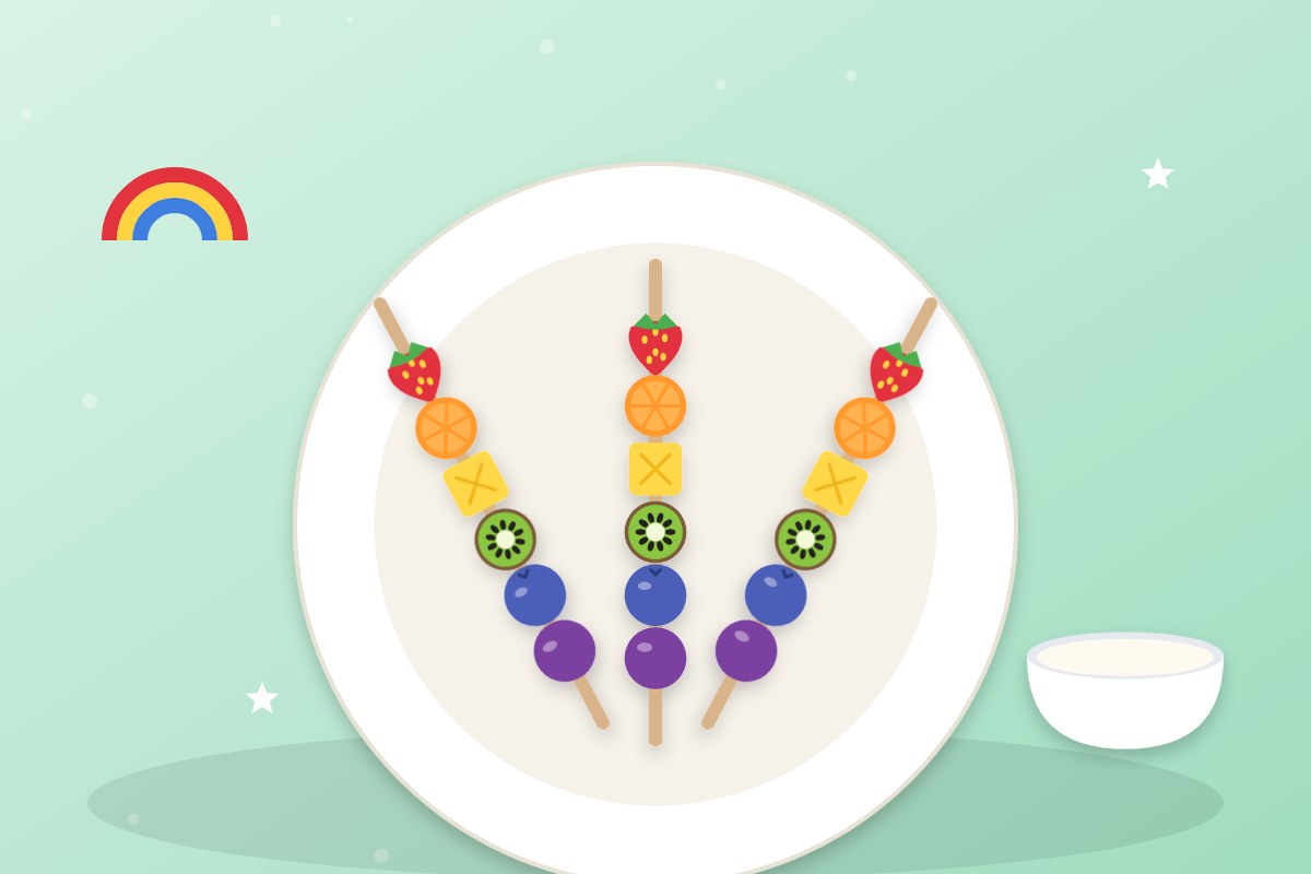 Tres brochetas de fruta con los colores del arcoíris sobre un plato